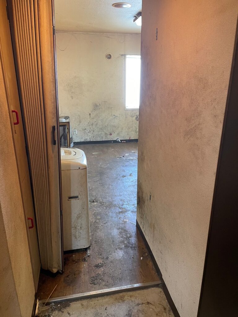 札幌のゴミ屋敷片付け後の廊下と部屋。ゴミが撤去され床や壁が見える状態に改善」