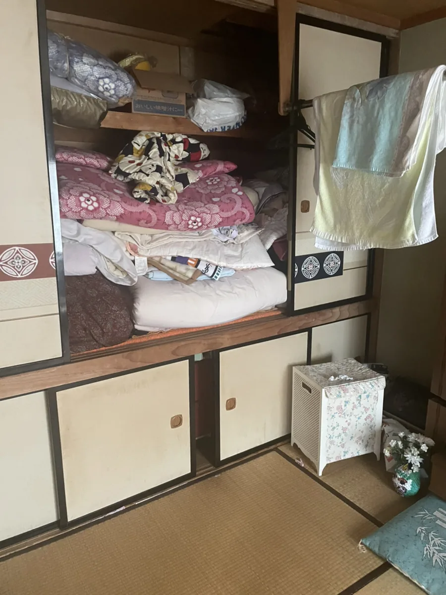 札幌市東区の遺品整理ビフォー - 和室の押入れに布団や衣類が詰まった状態