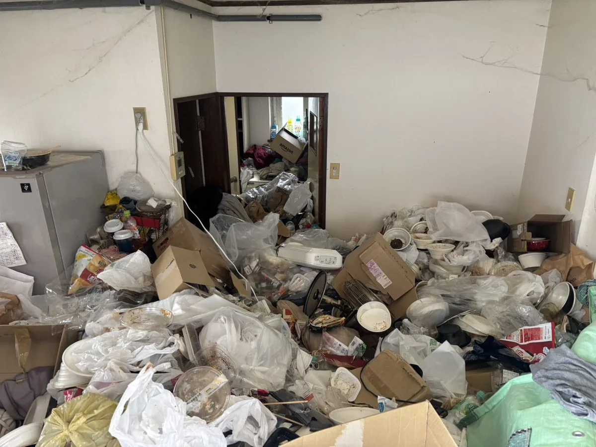 札幌市西区の戸建て居間、片付け前。床一面に生活ゴミが積み上がったゴミ屋敷のビフォー写真